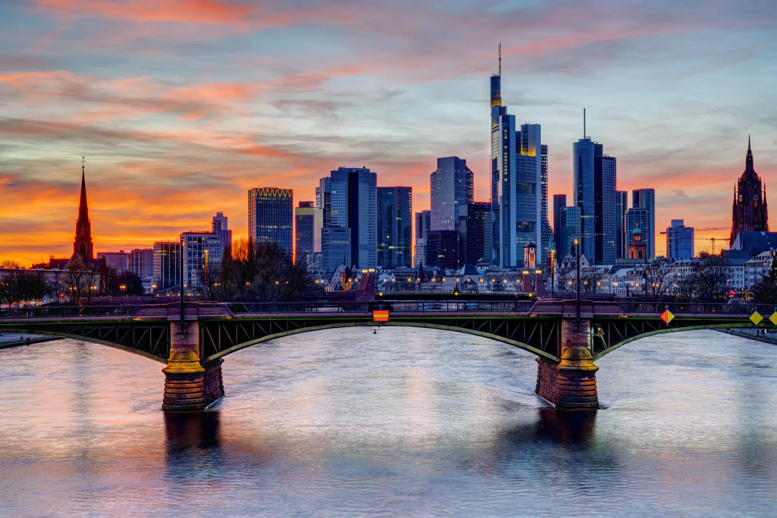 Frankfurter Skyline mit Ignatz-Bubis-Brücke über dem Main zur blauen Stunde